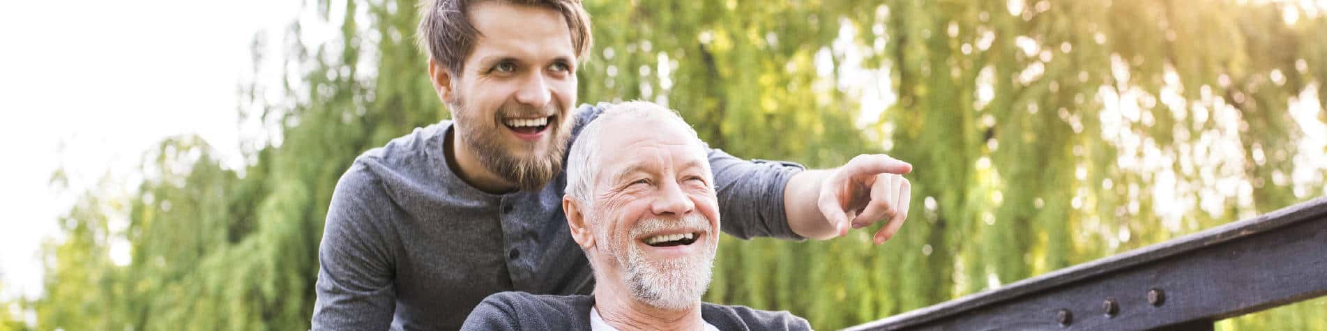 Young Man Smiling and Pointing with a Smiling Old Man