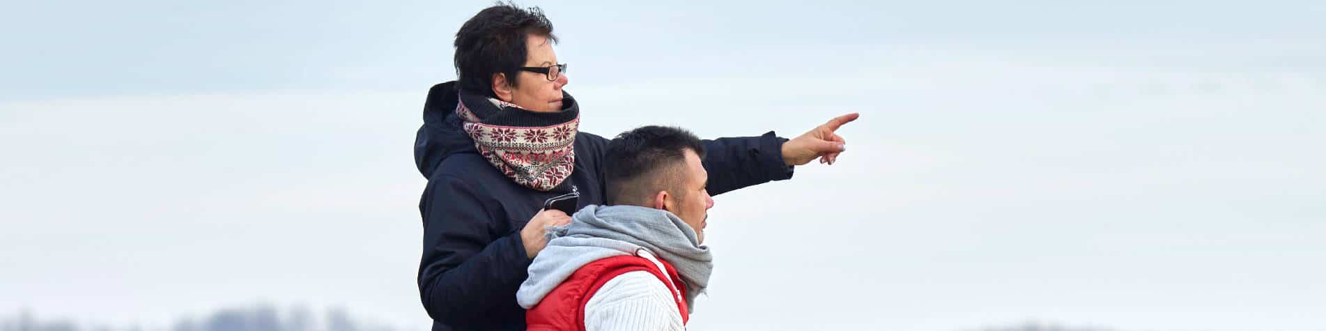 Caring for Someone With Muscular Dystrophy, Woman Pointing Outward with a Wheelchair-Using Man