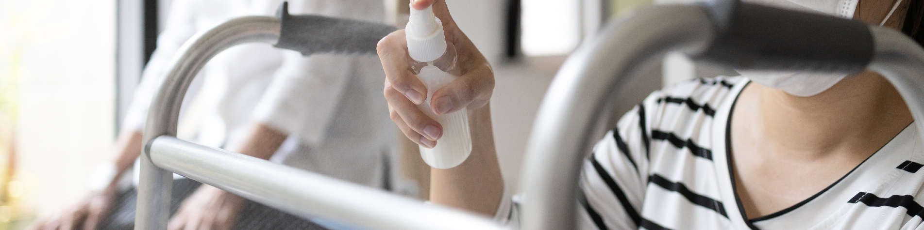 Caregiver Job Duties, Woman Sanitizing an Elderly Client's Walker